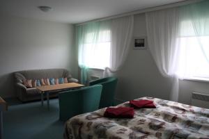 HeltermaaHeltermaa Hostel的酒店客房配有床、沙发和桌子。