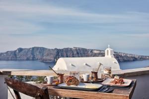 伊亚白珍珠别墅酒店的一张带食物的桌子,享有海景
