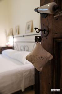 洛雷托·阿普鲁蒂诺Masseria del Vino的一间卧室,配有一张床和一把钥匙,上面有单词ums