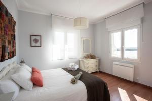 坎巴多斯Vivienda O Pombal的卧室设有一张白色大床和一扇窗户。