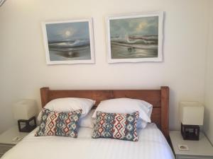 纽基SeaQuest 5的卧室配有一张墙上有两张照片的床。