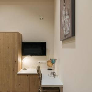 Sint-Martens-LennikB&B De Windheer的客房设有书桌和墙上的电视