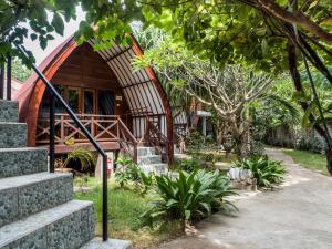 吉利特拉旺安吉利海龟度假酒店的花园中带弧形屋顶和楼梯的房子