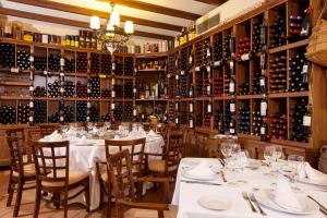 安特克拉芬卡埃斯拉瓦酒店的餐厅设有白色桌子和瓶装葡萄酒