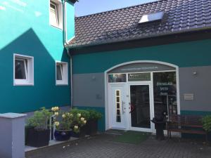 韦斯特尔堡Ferienwohnung Westerburg的蓝色的建筑,外面有门和长凳