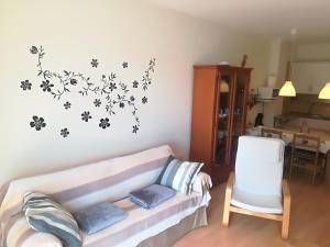 巴哈马尔Bajamar的客厅配有沙发,墙上挂着鲜花