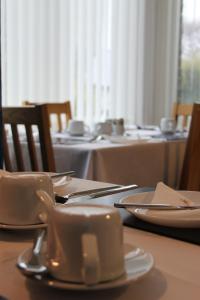 尚克林圣莱昂纳茨旅馆的桌子上放有盘子和餐具