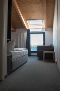 施特拉尔松德Hotel Alter Hafenspeicher的一间卧室配有一张床、一张沙发和一个窗口