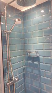 特伦托河上的纽瓦克博蒙德克罗斯宾馆的浴室设有蓝色瓷砖墙和淋浴。