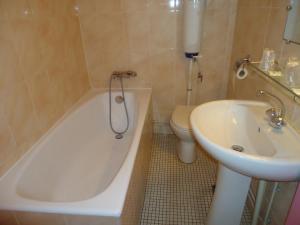 巴黎贝洁酒店的浴室配有卫生间、浴缸和水槽。