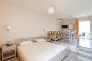 斯塔罗斯菲德拉酒店的一间白色的房间,配有床和饭厅
