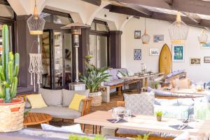 米尼赞海滩Single Fin Hotel & Lodge的餐厅内带沙发和桌子的庭院
