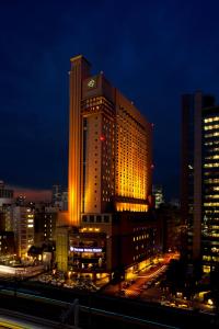 东京东京第一酒店 的一座大建筑,晚上有灯光在城市里