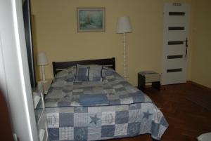格丁尼亚Homestay Kapitańska 9的一间卧室配有一张带蓝色和灰色被子的床