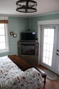 MatlockAaron's on the Lake的一间卧室配有一张床、一个壁炉和一台电视。