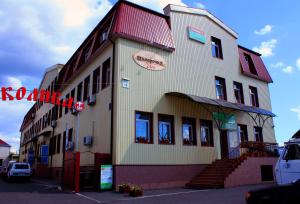 基辅迷你酒店－Elektrotechnichnaya Street 18的一面有红色标志的建筑物