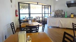 阿卡普尔科拉鲁皮塔别墅酒店的餐厅设有木桌、椅子和柜台