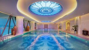 武汉武汉万达瑞华酒店的一个带彩绘玻璃窗的天花板的游泳池