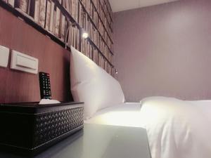 台北耘荷居 Yún Inn的卧室配有白色的床和遥控器