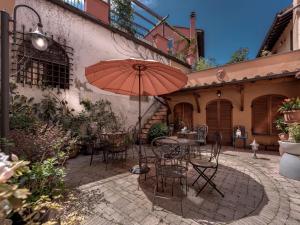 彼得拉桑塔帕拉吉酒店的一个带桌椅和遮阳伞的庭院