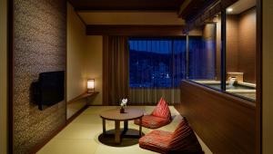 伊东拉佛蕾俱乐部伊东温泉日式旅馆(Laforet Ito Onsen Yunoniwa)的酒店客房设有桌椅和窗户。