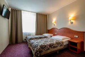 克拉科夫克拉库斯酒店的酒店客房设有两张床和窗户。