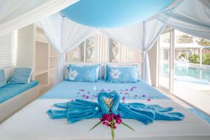 吉利特拉旺安巴厘岛海滩吉利别墅的一间卧室,床上有鸟