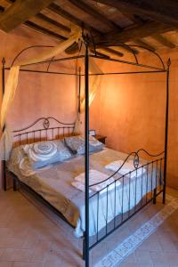 瓦尔法布里卡区Castello Di Giomici的一间卧室配有一张带金属天蓬的床