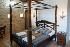 瓦尔法布里卡区Castello Di Giomici的一间卧室配有一张天蓬床和一张桌子