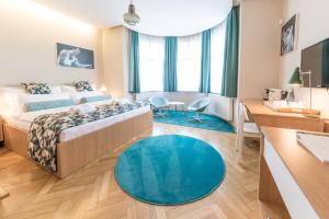 捷克克鲁姆洛夫贝阿提卡别墅精品酒店的一间卧室配有一张床和蓝色地毯