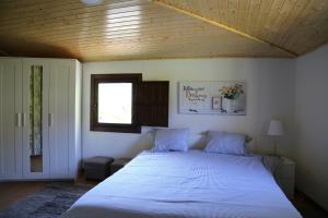La TeijeiraCasa Juca的卧室配有一张白色大床和木制天花板