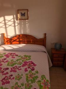 塔马里特Cala Azul 304-306 Tamarit的一间卧室配有一张带花被的床