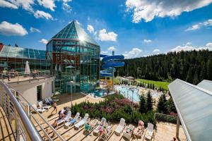 布科维纳-塔钱斯卡Hotel BUKOVINA的享有带游泳池和大楼的度假村景色