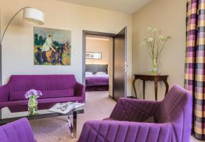 克拉科夫考萨克酒店的客厅配有紫色沙发和床。