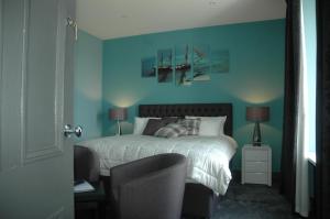 勒威克Maryfield House Hotel的一间卧室配有一张蓝色墙壁的床