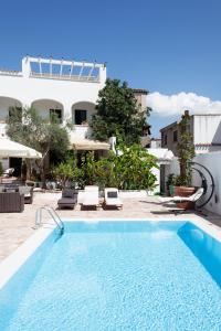 IrgoliGulf of Orosei Luxury Mediterranean House的一座带椅子的大型游泳池和一座建筑