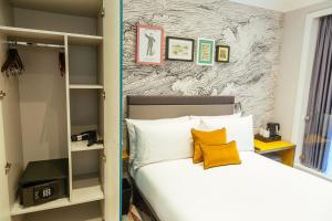 伦敦奥利弗广场酒店的一间卧室配有带白色床单和黄色枕头的床。