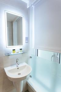 伦敦奥利弗广场酒店的白色的浴室设有水槽和镜子