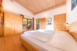卢松Pardellerhof Ferienhaus的一间卧室配有一张带木制橱柜的大床