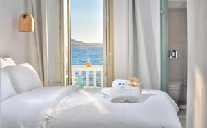 米克诺斯城Little Venice Suites的一间卧室设有一张床,享有海景