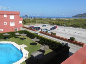 阿尔赫西拉斯Apartamento a la Playa的享有带遮阳伞和道路的游泳池的景色