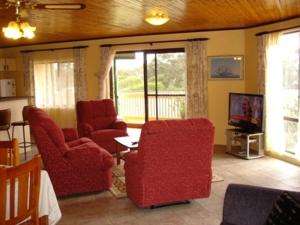 安特兰斯湖滨汽车旅馆的客厅配有2把红色椅子和电视
