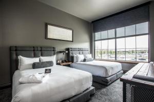 印第安纳波利斯Ironworks Hotel Indy的酒店客房设有两张床和窗户。