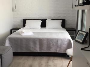 雅典雅典景致阁楼 - 01公寓的一间卧室配有带白色床单和白色枕头的床。