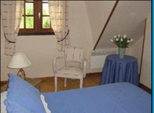 CommesGîte La MER的一间卧室配有蓝色的床和桌椅