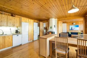 BjörköbyHoliday Lakefront house的厨房设有木制天花板和桌椅