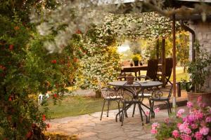 托迪特努纳迪卡诺尼卡酒店的花园里种满鲜花,配有桌椅