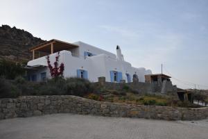 凯勒里瓦迪Andromeda Mykonos Villas & Suites的山丘上一座石墙房子
