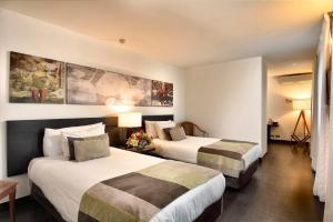 圣地亚哥普罗维登斯欧洲电信酒店的一间酒店客房,房间内设有两张床