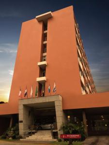 圣玛丽亚Altadomo Hotel的一座大型橙色建筑,前面有旗帜